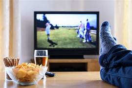 A cozy living room scene featuring a TV, snacks, and a drink, perfect for relaxation and entertainment at home.